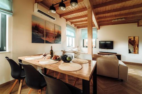 a dining room with a wooden table and chairs at Morze Tu in Stegna