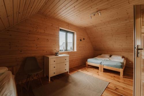 a bedroom with a bed and a window in a wooden room at Morze Tu in Stegna