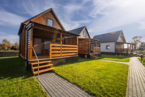 a log home with a grassy yard at Morze Tu in Stegna