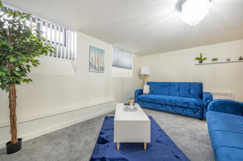 a living room with a blue couch and a table at Basement Bliss Hideaway in Bradford