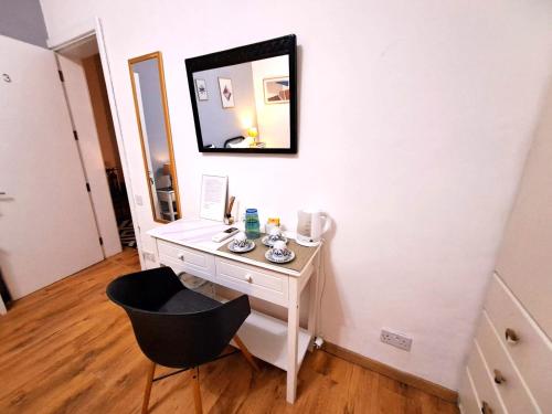 a white dressing table with a mirror and a chair at Rotas B in St Julian's