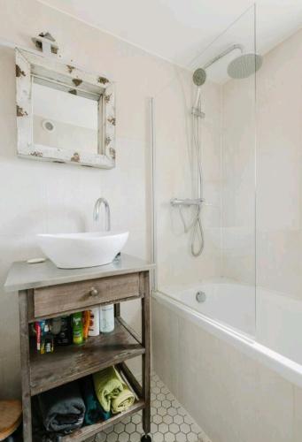 ein Badezimmer mit einem Waschbecken, einer Badewanne und einem Spiegel in der Unterkunft Casa Suzanne in Herven