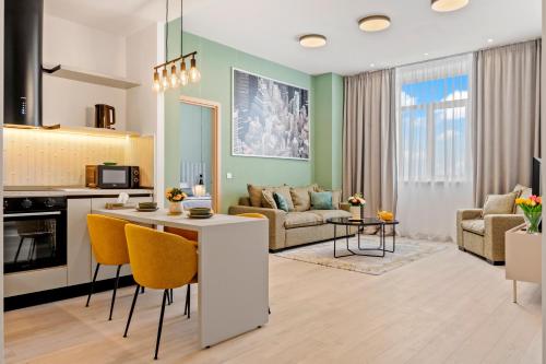 una cucina e un soggiorno con pareti verdi e sedie gialle di Rin Luxury Apartments Pool & Spa a Bucarest