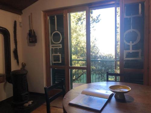 Cette chambre dispose d'une table en bois et d'une grande fenêtre. dans l'établissement La casa di Nello Bini con vista su Firenze, à Bagno a Ripoli