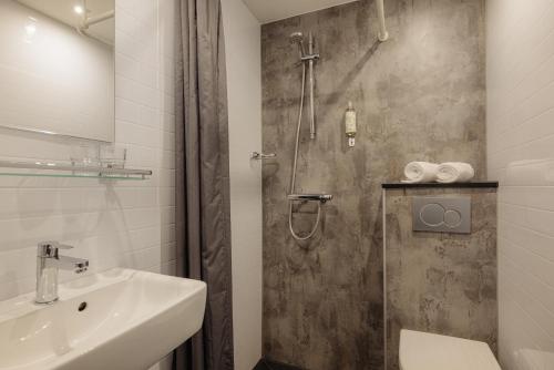 a bathroom with a shower and a sink at The Lancaster Hotel Amsterdam in Amsterdam