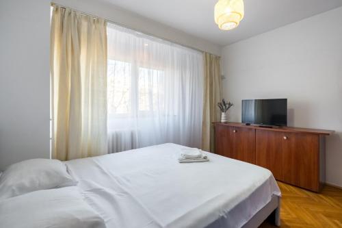 een slaapkamer met een wit bed en een raam bij Urban Dream Free Parking Near Parliament in Boekarest
