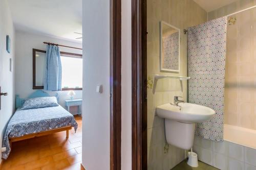 Un baño con lavabo y un dormitorio con cama. en Bonito apartamento, tranquilo y espacioso., en S'Algar