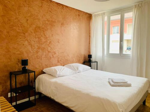 une chambre avec un lit blanc et une fenêtre dans l'établissement Spacieux T3 climatisé avec parking proche gare, à Villefranche-sur-Saône