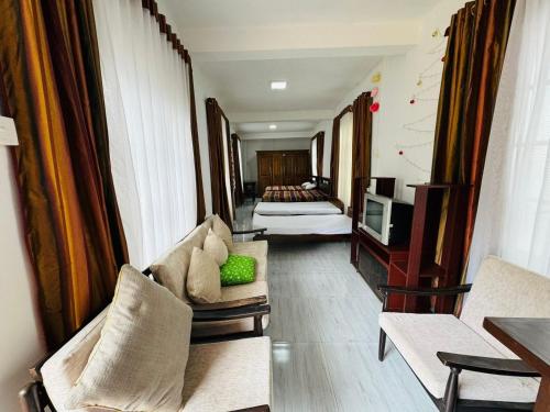 a living room with a couch and a bed at Shanthi Guest house in Diyatalawa
