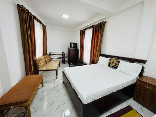 ein Schlafzimmer mit einem Bett und einem Stuhl darin in der Unterkunft Shanthi Guest house in Diyatalawa