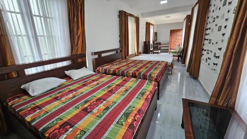 a hotel room with two beds in a bedroom at Shanthi Guest house in Diyatalawa