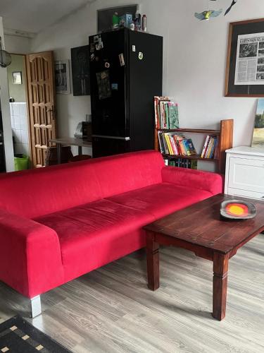a red couch in a living room with a coffee table at Apartament-samodzielne mieszkanie-Agroturystyka-puszcza kampinoska in Leoncin