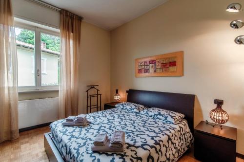 een slaapkamer met een bed met schoenen erop bij Vista Lario Apartment - Aqua Apartments in Cernobbio