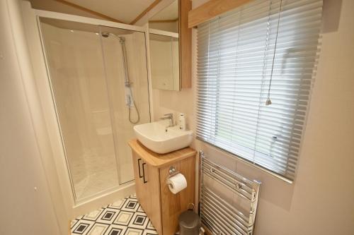 a small bathroom with a sink and a shower at Tranquility at Chantry Lodge in Clitheroe