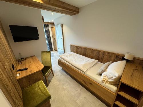 Schlafzimmer mit einem Bett, einem Schreibtisch und einem TV in der Unterkunft Hotel Gasthof zum Wulfen in Sulzbach-Rosenberg