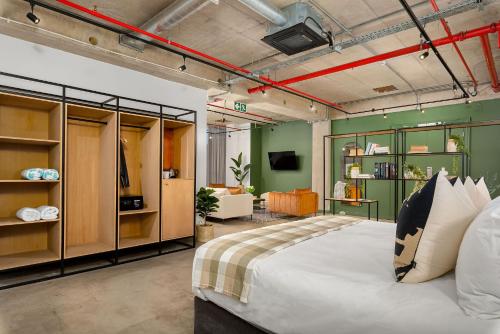 a bedroom with a large bed and a living room at Neighbourgood Loop Street in Cape Town