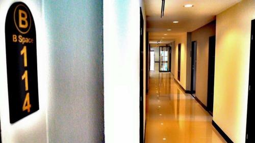 a hallway in a building with a sign on the wall at B Space Residence in Nong Prue