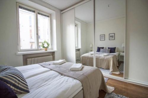 a bedroom with two beds and a large mirror at 2ndhomes Fabianinkatu Apartments in Helsinki