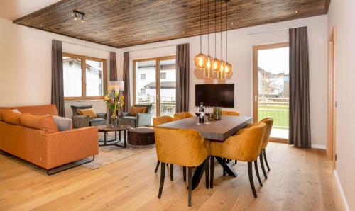 a dining room and living room with a table and chairs at Residenz Illyrica Tirol in Westendorf