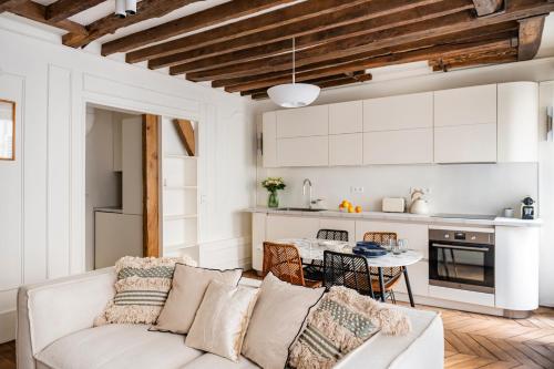 un salon blanc avec un canapé et une table dans l'établissement Ile-Saint-Louis apartment, à Paris