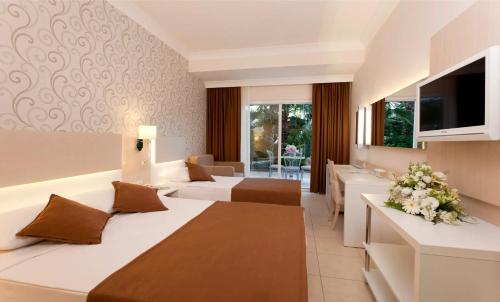 Habitación de hotel con 2 camas y TV en Club Mermaid Village, en Avsallar
