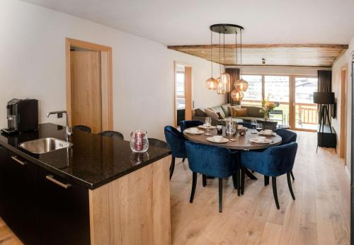 a kitchen and dining room with a table and blue chairs at Residenz Illyrica Tirol in Westendorf