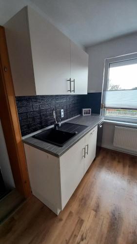 una cocina vacía con fregadero y ventana en Ferienwohnung Dschungel en Emden