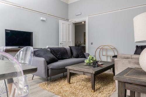 a living room with a couch and a table at Beautiful 4 bed flat in perfect central location in Glasgow