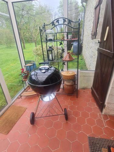 a bbq grill on a patio with a window at Maison à Rocquemont (60800) in Rocquemont