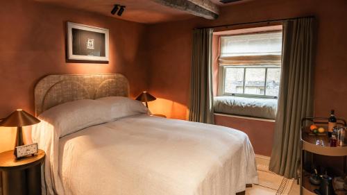 a bedroom with a white bed and a window at BULL Burford in Burford