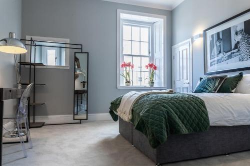 sypialnia z łóżkiem z zielonym kocem w obiekcie Beautiful 4 bed flat in perfect central location w Glasgow