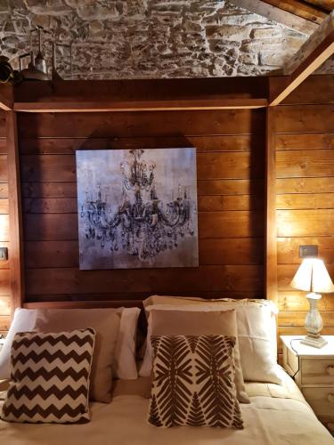 a bedroom with a bed with a painting on the wall at Il Meriggio - Rooms & Breakfast in Mezzenile