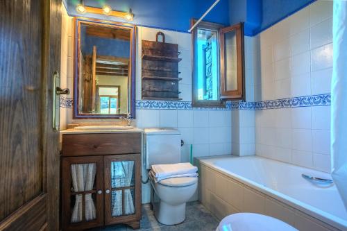 a bathroom with a toilet and a tub and a sink at La Molina IX in La Molina