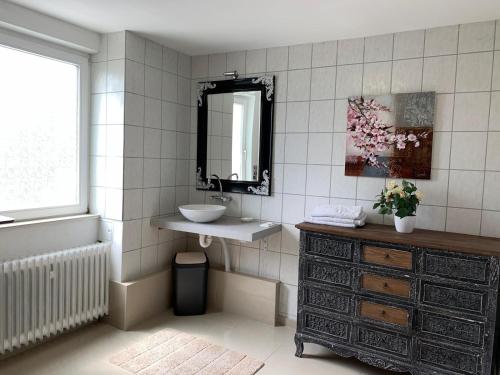 La salle de bains est pourvue d'un lavabo et d'un miroir. dans l'établissement Haus Michel, à Bad Wildungen