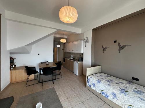 a bedroom with a bed and a table and a kitchen at Thalassa Apartments in Myrtos