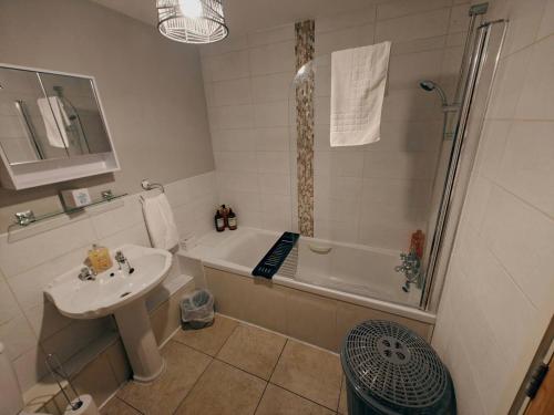 a bathroom with a sink and a tub and a shower at 2br Cosy City Centre Apartment in Belfast