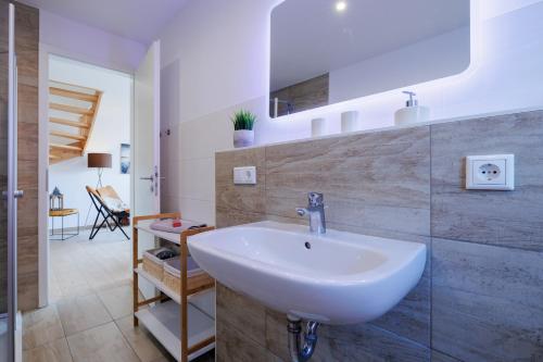 ein Bad mit einem weißen Waschbecken im Zimmer in der Unterkunft Suite Strandrose in Zingst