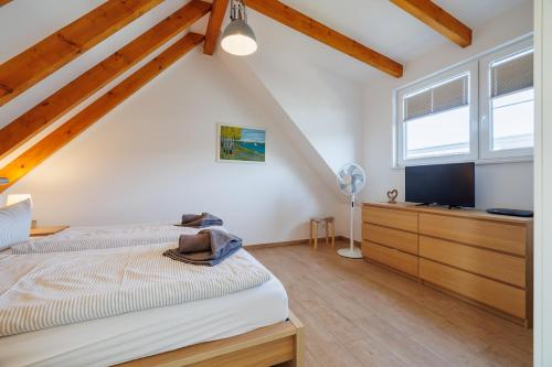 a bedroom with a bed and a flat screen tv at Suite Strandrose in Zingst