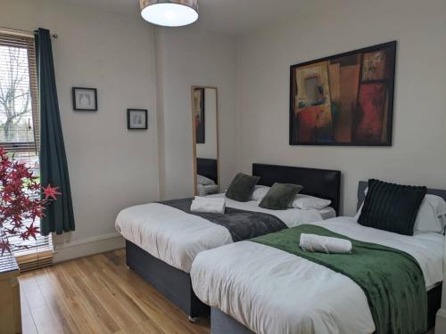 a bedroom with two beds and a window at 2br Modern Luxury Loft Apartment in Belfast