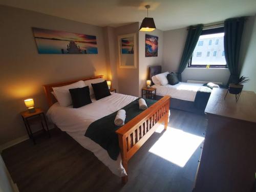 um quarto com 2 camas e uma janela em 2br Spacious City Centre Apartment em Belfast