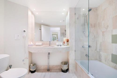 ein Bad mit einer Dusche, einem WC und einem Waschbecken in der Unterkunft Ocean View Surfers Paradise Studio Close to Beach in Gold Coast