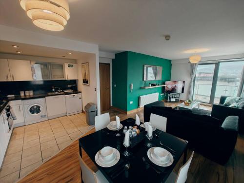 a living room with a dining table and a kitchen at 2br Mountain View City Centre in Belfast