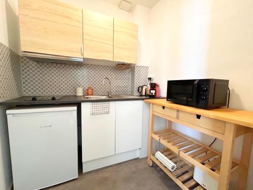 une petite cuisine avec un comptoir et un micro-ondes dans l'établissement EMMA - Centre Historique - Parking privée, à Auch