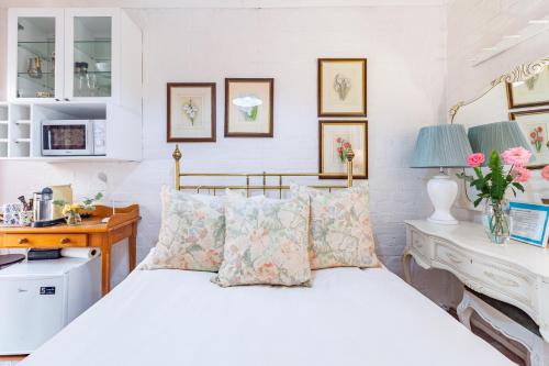 a bedroom with a white bed with pillows and a desk at Kings and Kent in Cape Town
