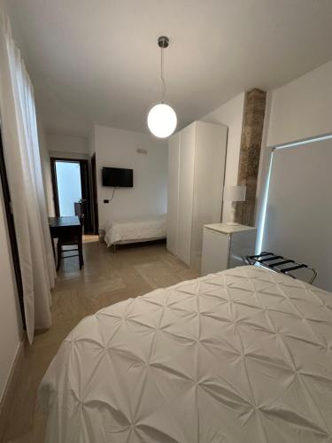 a bedroom with a bed and a room with a desk at Crispi 10 in Floridia