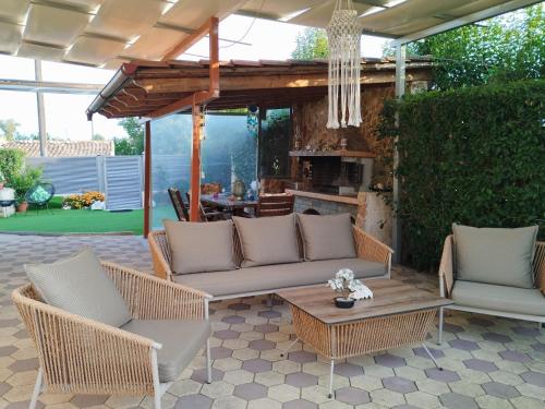 a patio with wicker furniture and a fireplace at Luxury Villas Chrysa Private Pool & Spa in Nafplio