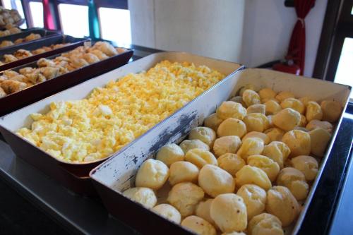 a display of trays of food on a counter at Satélite - Campos do Jordão in Campos do Jordão