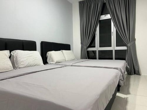 a bedroom with two beds and a window at Ipoh Town Anderson Hana Suite 7 paxs 2R2B in Ipoh