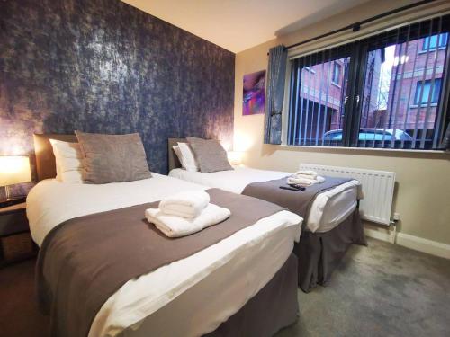 1 Schlafzimmer mit 2 Betten und einem Fenster in der Unterkunft Belfast Central 2 Bedroom Luxurious Modern Stay in Belfast
