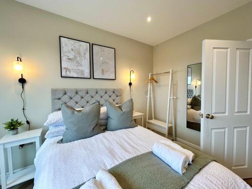 1 dormitorio con 1 cama blanca grande con almohadas azules en Number 11 Croft House, en Pembrokeshire